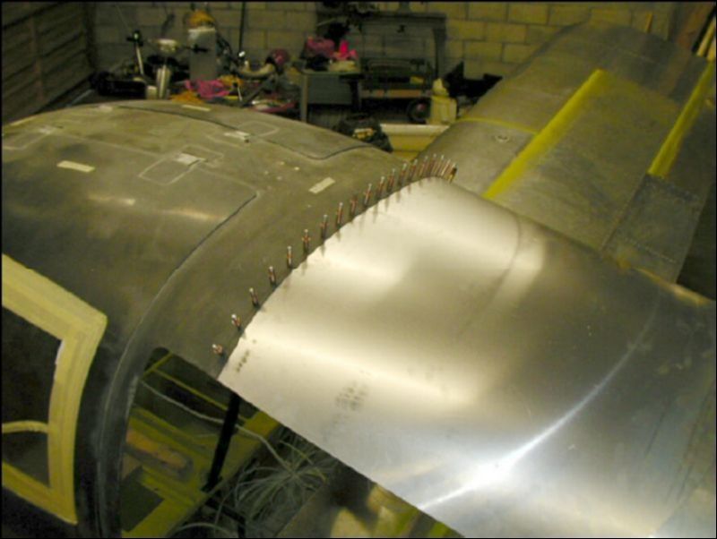 Install the top front fuselage skin.  This skin goes under the canopy and over the bagage area bulkhead.  Drill and cleco the front of this skin starting in the center and working your way down each side.