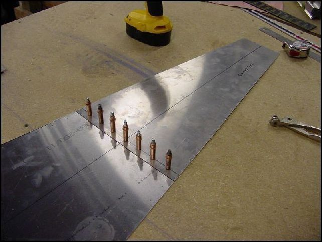 Mark the bottom skin 20 mm from bottom and draw a line across it.  Over lap the rear bottom skin up to this line and drill rivet holes A4 pitch 35.  Be sure to leave a space on both sides for the longerons.  I started at the center line which made for a nice even space on each side.