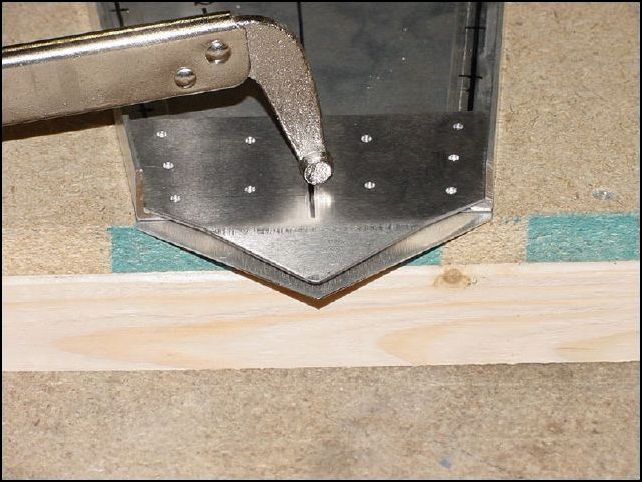 Place lower bottom rudder hinge, shim, lower top rudder hinge, and lower rear longerons in to position on the top of the bottom skin and clamp in place.