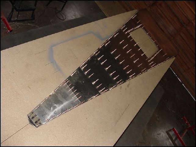 This image shows the rear fuselage floor sub-assy with all the Z angles and longeron rivet holes drilled