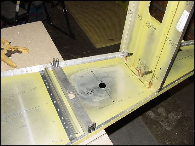 Measure 125mm back from the center of the hole in the battery support then measure 85mm left and right from that location.  Drill the two holes on the center line (1