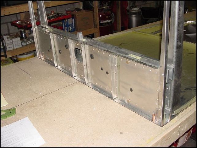 Position the front of the center spar to the front of the rear skin.  Drill one hole at each end into the table and cleco in place.  NOTE:  I also clecoed the rear floor to my table so that it will not move.  To do this I used the small holes that were already in the skin at each side and drilled holes in my table with a #40 drill bit.  Then clecoed with A3 clecos (silver ones).