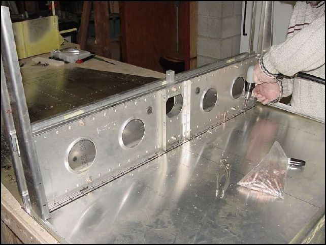 At this point I am happy that everything is fitting together nicely.  So, I removed the extrusions and center channel from the front bottom skin so that everything is now laying flat on the table again.  Then I finished drilling the rivet holes in the center spar.