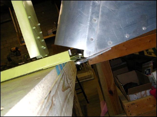 Drilled 1/4 inch holes in bottom rudder hinge of fuselage, marked the location of this hole on the lower rudder hinge, removed rudder and drilled lower hinge hole to 5/16 inch.  Installed bushing in 5/16 hole, reattached rudder with washer on bottom side of rudder hinge.  See drawings for complete details.