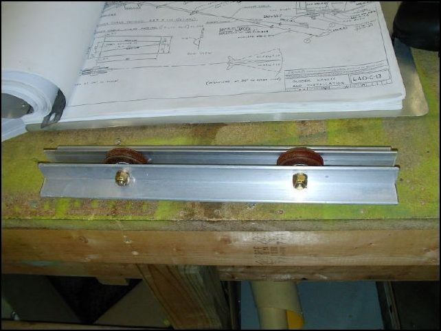 One thing I HATE about the CH-640 is how the control cables run through nylon tabs.  I made this change in my CH-300 and it worked so well that I am building my CH-640 with the same modifications.  First let's deal with the rudder control cables.  I took two Ls and made a bracket to hold two pulleys.  This bracket will be bolted to the fuselage just forward of the rear access door.  The location of the pulleys should be just enough to make the cables not rub on the rear side skin Z at the location where the cables exit the fuselage.  Be sure to drill holes for a safety pin so the cables can not jump out of the pulleys.  I know, this picture shows that I drilled the safety pin hole on the wrong side of the right pulley.  I will correct this when I install it.