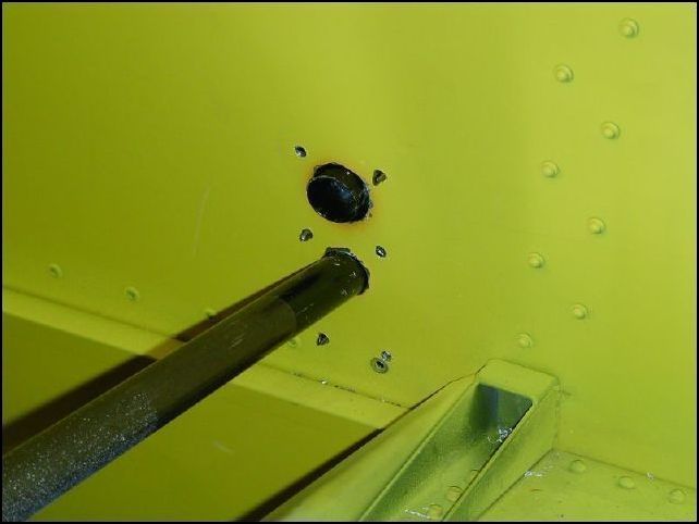 This image shows the inside of the firewall with the control rod riveted in place.