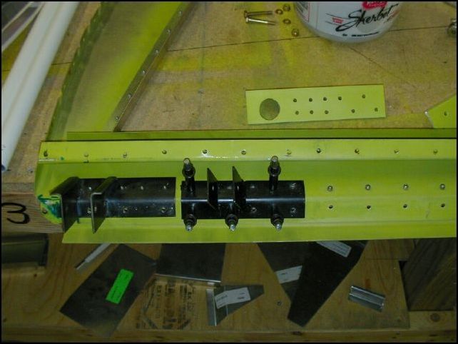 Position the left pivoting bracket to the bottom of the baggage area bulk head 152 mm from the side skin area.  Drill and cleco for A5 rivets.