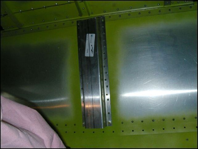 Install 20-F-11-4 (channel) to the back of the rear seat back in the center.  I know, mine is a mess, I drilled the holes on the bench before installing it and had the darn thing upside down.  GRRRRR.  Oh well, it now has twice the rivets it should and it will be covered by the plywood for the seat so I am going to just leave it alone.