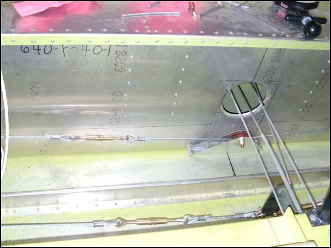 Adjust the aileron cable tension and aileron deflection.