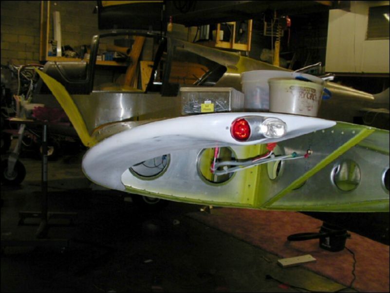 Install the strobe and marker light in the fiberglass wing tip.  Deburr, clean, and prime all wing tip parts then rivet the fiberglass tip to the wing.