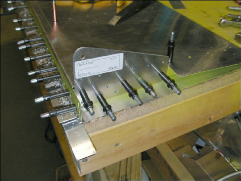 Drill and cleco the flap control lever to the side of rib one.