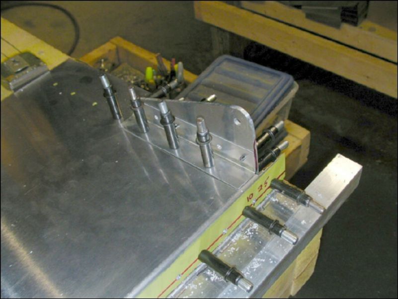 Drill and cleco an L angle to the top of the flap skin and to the flap control lever.