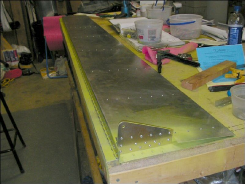 Deburr, clean, prime, and rivet the flap hinge and flap control lever