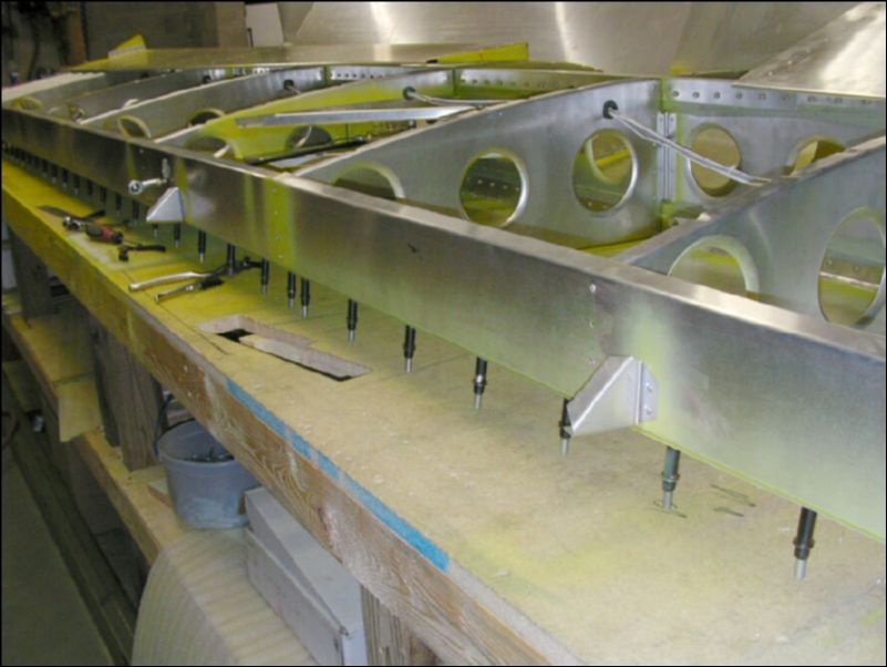 Deburr, clean, prime, and rivet the aileron support gussets.