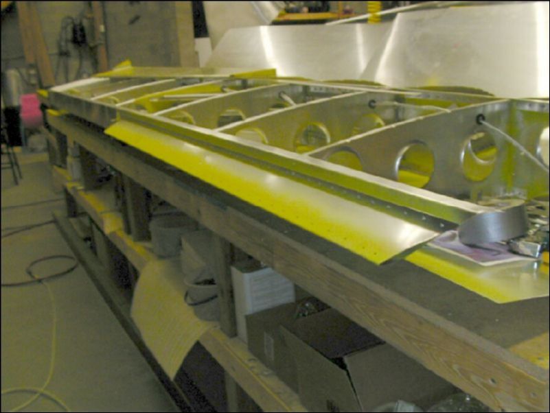 Deburr, clean, prime, and rivet the aileron support channel to the rear channel.