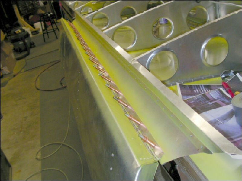 Drill and cleco the aileron hinge to the aileron support channel.