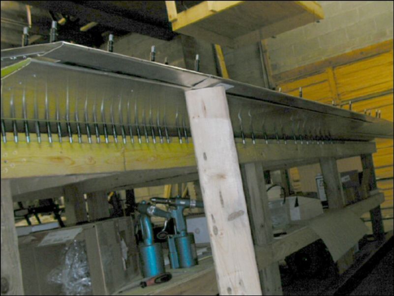 Drill and cleco the flap hinge to the rear channel between the skin and the channel.