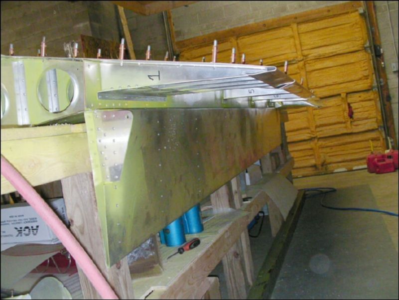 Drill and cleco the flap hinge to the rear channel between the skin and the channel.