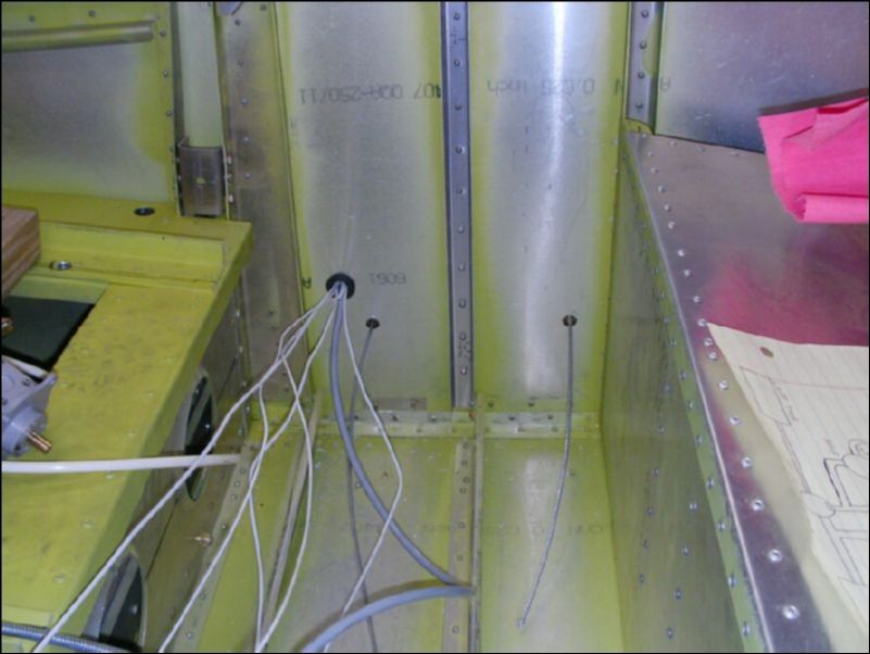 Position right wing near aircraft, drill holes in fuselage for control cables and wires.  Pull cables and wires through holes.