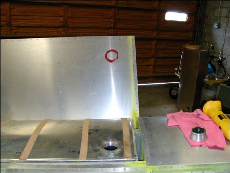 Mark top wing skin for fuel tank filler neck.  To do this I put a bead of silicone rubber around the hole of the gas tank, then closed the skin and pressed down to mark the location of the hole.